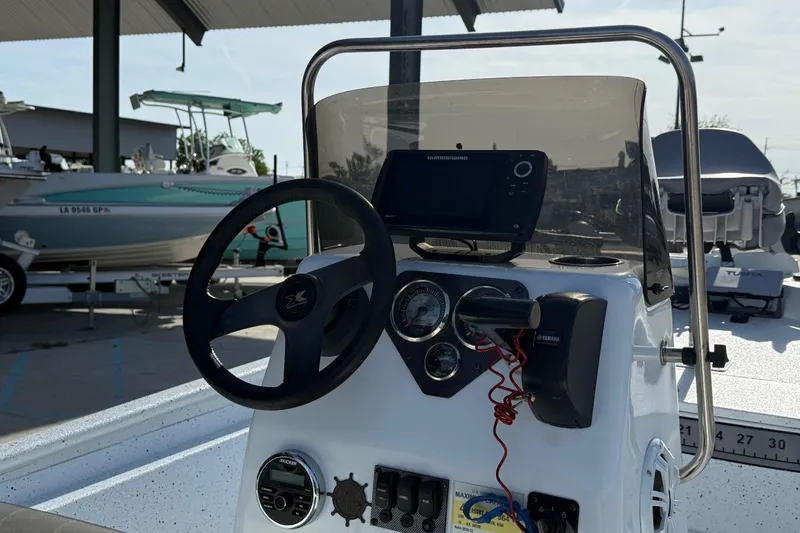 Slide: The Image of 2021 Alumaweld Xpress boat dashboard with steering wheel and navigation equipment. - 11