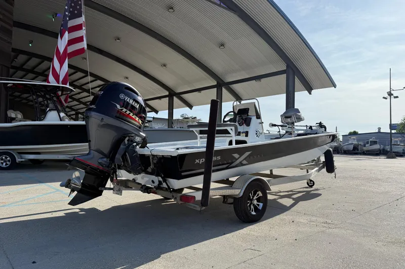 Slide: The Image of 2021 Alumaweld Xpress boat with Yamaha motor, parked under a canopy. - 3