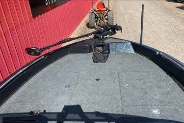 Slide: The Image of 2021 Nitro ZV19 boat deck with trolling motor, parked near a red building. - 3