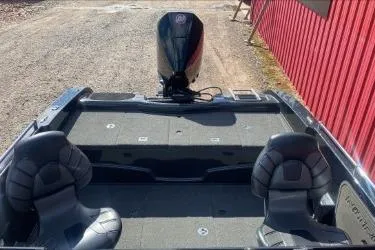 Slide: The Image of 2021 Nitro ZV19 boat with dual seats and outboard motor, parked near a red building. - 7