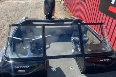 Slide: The Image of 2021 Nitro ZV19 boat with dual consoles and windshield, parked near a red building. - 8