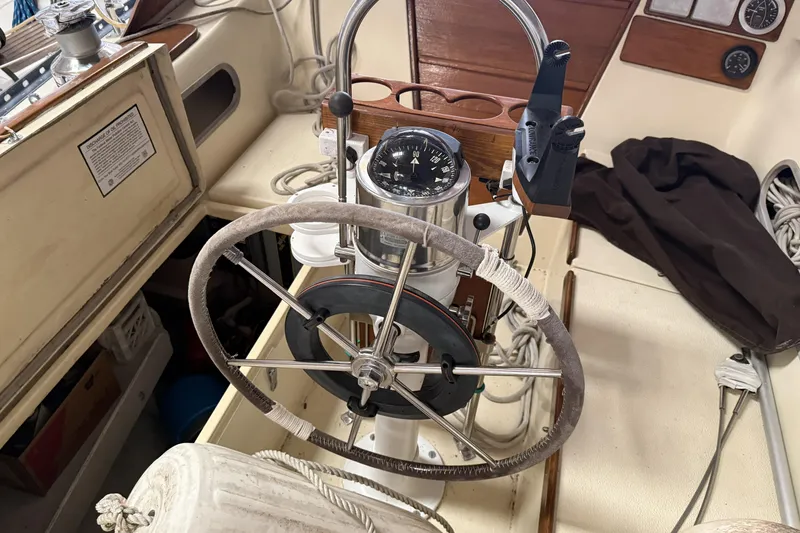 Slide: The Image of 1977 Islander 32 sailboat cockpit with steering wheel and compass. - 11
