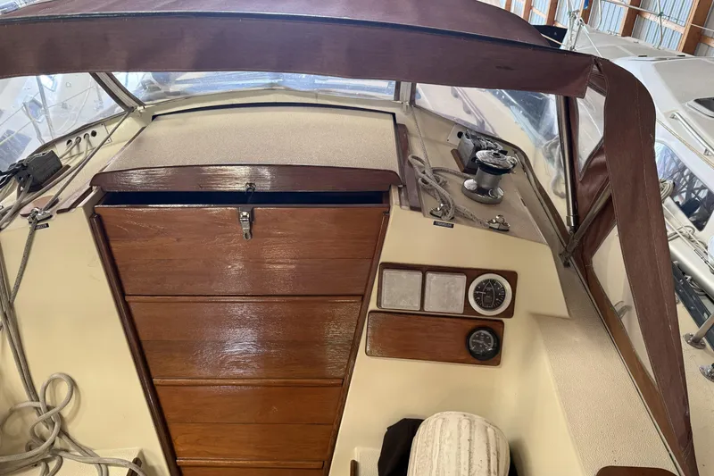 Slide: The Image of 1977 Islander 32 sailboat cockpit with wooden hatch, gauges, and winch. - 13