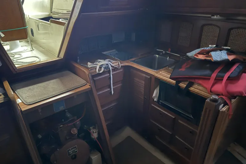 Slide: The Image of Interior of a 1977 Islander 32 sailboat featuring a compact kitchen area. - 17