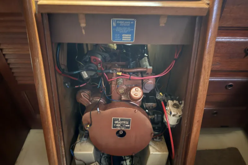 Slide: The Image of Engine compartment of a 1977 Islander 32 sailboat, featuring wiring and components. - 18