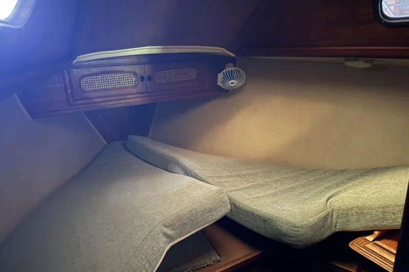 Slide: The Image of Cozy cabin interior of a 1977 Islander 32 sailboat with cushioned seating and wooden cabinetry. - 19