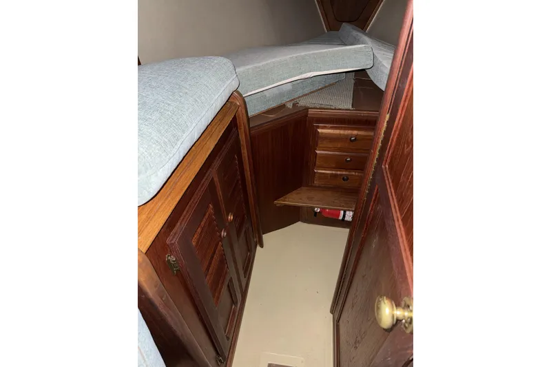 Slide: The Image of 1977 Islander 32 sailboat cabin interior with wooden cabinets and cushioned seating. - 21