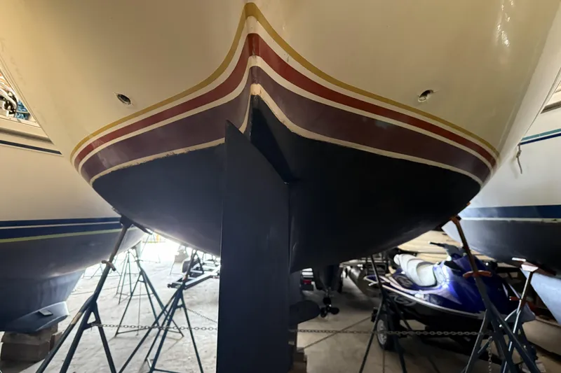 Slide: The Image of 1977 Islander 32 sailboat hull in storage, showcasing keel and colorful stripes. - 24