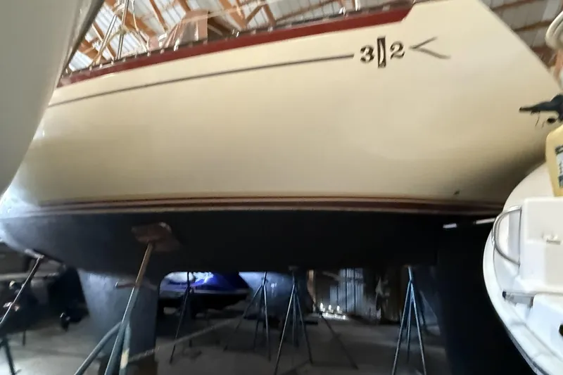 Slide: The Image of 1977 Islander 32 sailboat in storage, hull supported by stands. - 4
