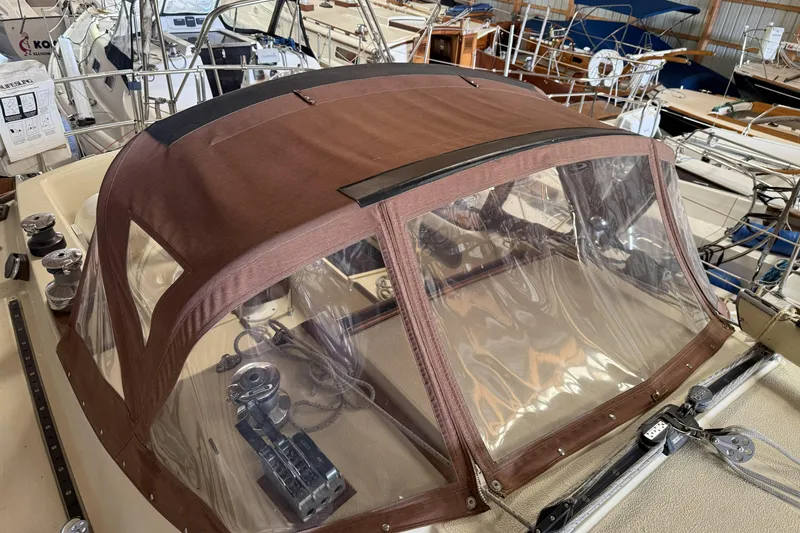 Slide: The Image of 1977 Islander 32 sailboat with brown canvas cover in a marina setting. - 7