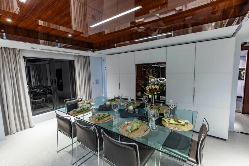 Slide: The Image of Luxurious dining area on 2020 Riva 110' Dolcevita yacht with elegant glass table setting. - 6
