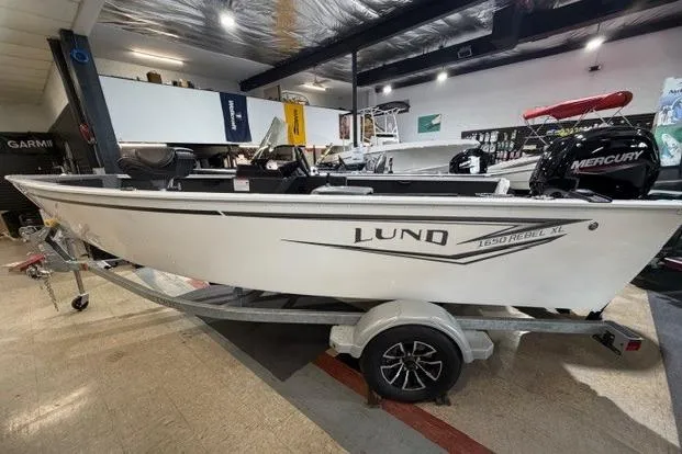 The Image of 2026 Lund 1650 Rebel XL SS boat on trailer in showroom, side view. - 0