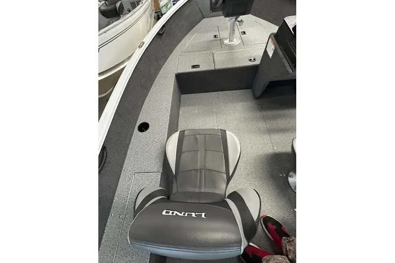 Slide: The Image of 2026 Lund 1650 Rebel XL SS boat interior with gray seating and carpeted floor. - 8