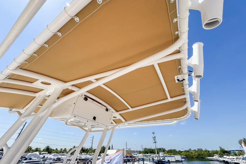 Slide: The Image of Edgewater 208CC 2025 boat canopy with rod holders, blue sky. - 7