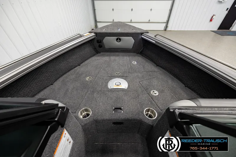 Slide: The Image of Interior view of a 2026 Lund 1975 Tyee boat, featuring carpeted flooring and cup holders. - 14