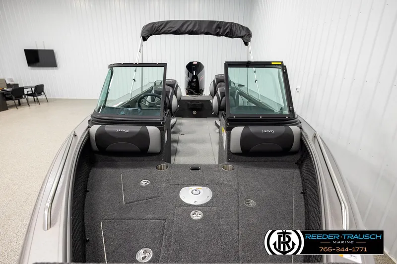Slide: The Image of 2026 Lund 1975 Tyee boat interior with seating and windshield in showroom. - 15
