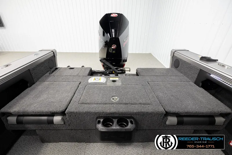 Slide: The Image of 2026 Lund 1975 Tyee boat interior with motor, featuring carpeted deck and storage compartments. - 19
