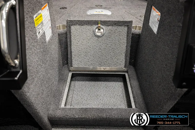 Slide: The Image of Interior storage compartment of 2026 Lund 1975 Tyee boat, featuring carpeted finish and secure latch. - 21