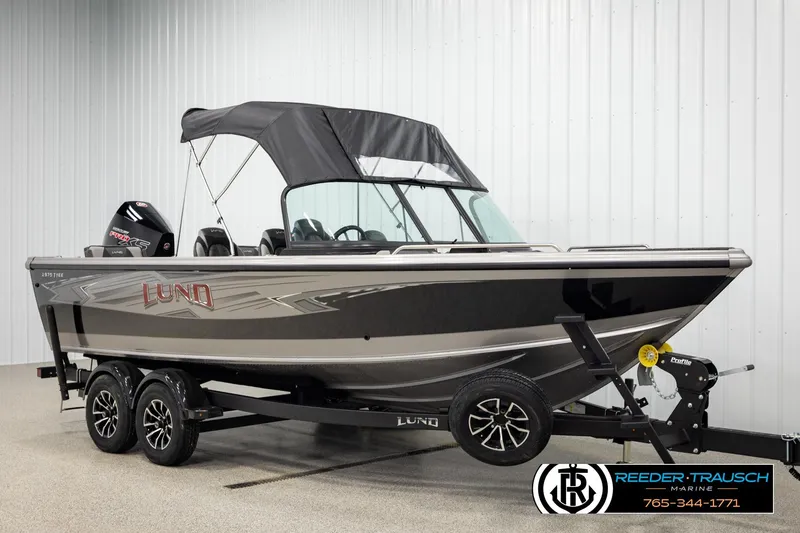 Slide: The Image of 2026 Lund 1975 Tyee boat with canopy on trailer in showroom. - 3