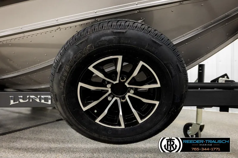 Slide: The Image of Close-up of a 2026 Lund 1975 Tyee boat trailer wheel, featuring sleek black and silver design. - 52