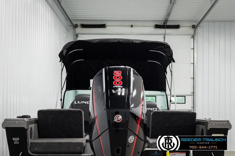 Slide: The Image of 2026 Lund 1975 Tyee boat with 200 HP Mercury engine in a showroom. - 6