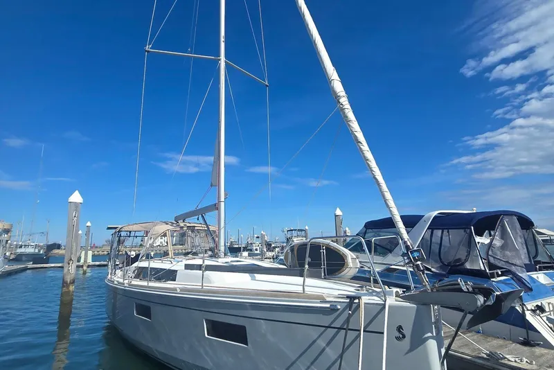 Slide: The Image of 2018 Beneteau Oceanis 38.1 sailboat docked at marina under clear blue sky. - 12