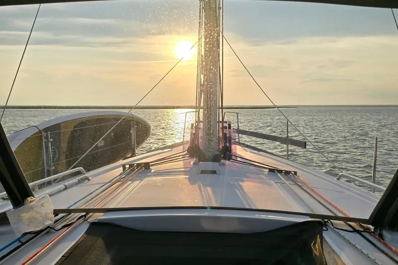 Slide: The Image of 2018 Beneteau Oceanis 38.1 sailing at sunset, serene ocean view from deck. - 13