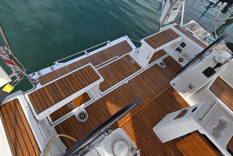 Slide: The Image of 2018 Beneteau Oceanis 38.1 yacht deck with teak flooring and dual steering wheels. - 18