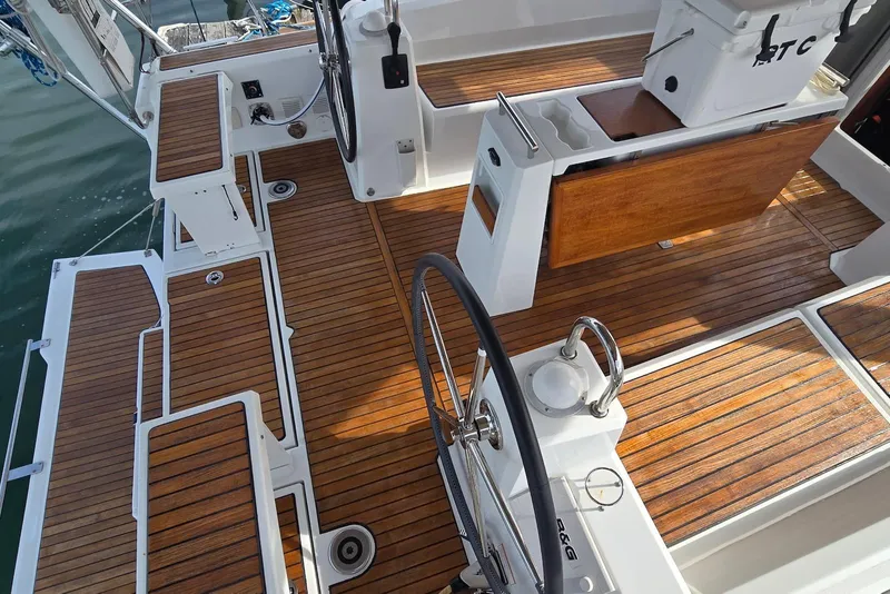 Slide: The Image of 2018 Beneteau Oceanis 38.1 yacht cockpit with teak flooring and dual steering wheels. - 19