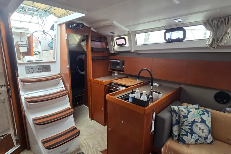 Slide: The Image of Interior of 2018 Beneteau Oceanis 38.1 yacht with modern kitchen and cozy seating area. - 20