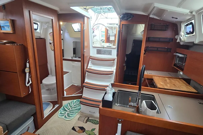 Slide: The Image of Interior of 2018 Beneteau Oceanis 38.1 yacht, featuring kitchen and bathroom areas. - 21