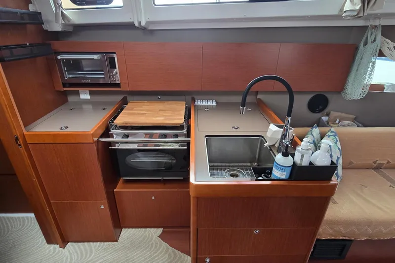 Slide: The Image of 2018 Beneteau Oceanis 38.1 yacht kitchen with sink, stove, and microwave. - 27