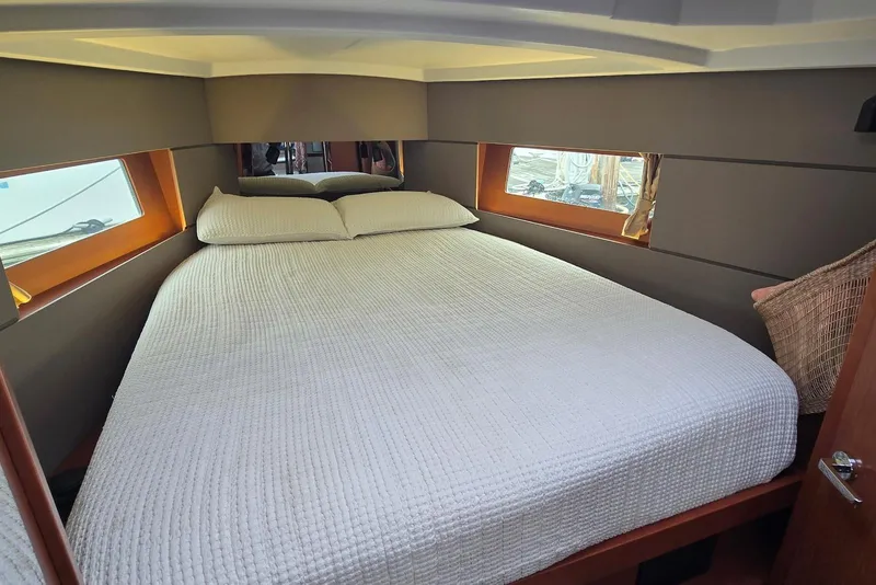 Slide: The Image of Cozy cabin interior of 2018 Beneteau Oceanis 38.1 with a comfortable bed and windows. - 28