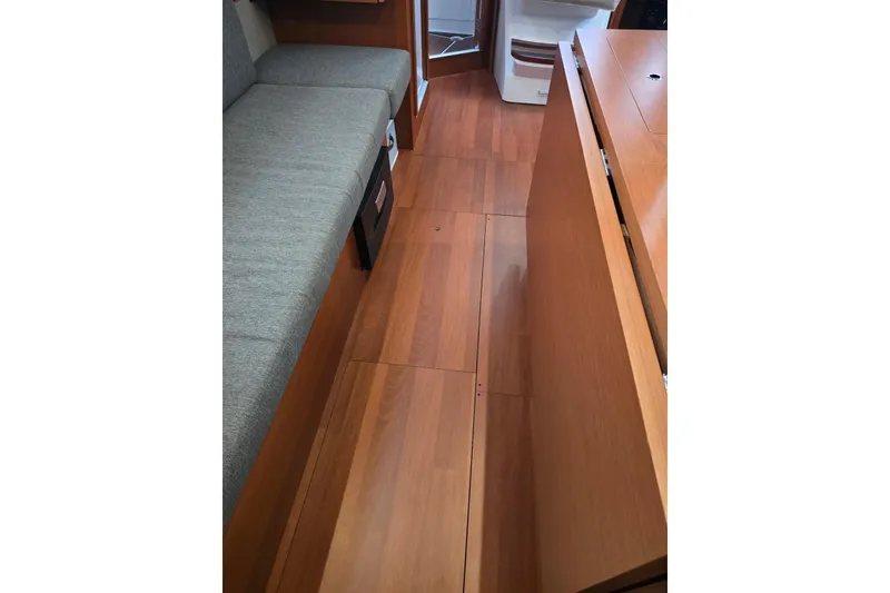 Slide: The Image of Interior of 2018 Beneteau Oceanis 38.1 yacht with wooden flooring and gray seating. - 30