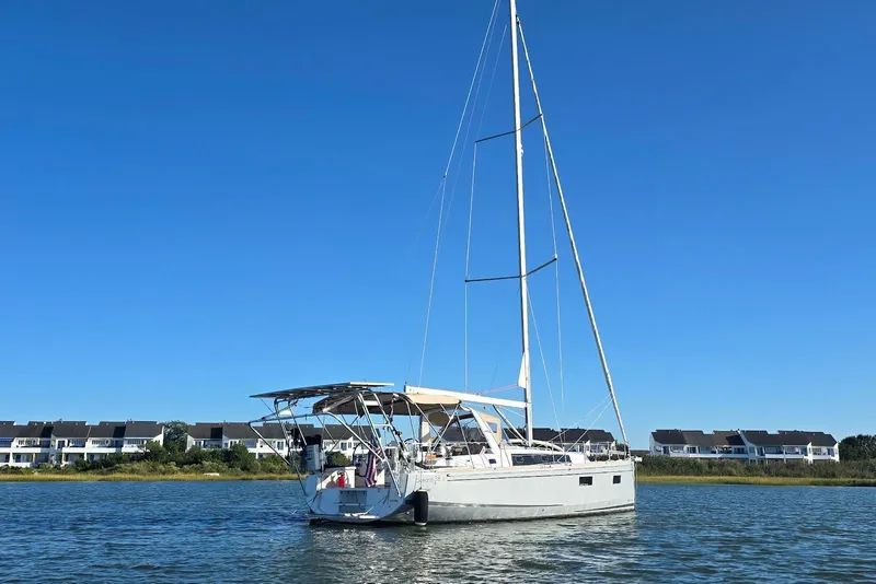 Slide: The Image of 2018 Beneteau Oceanis 38.1 sailboat on calm water with clear blue sky. - 5