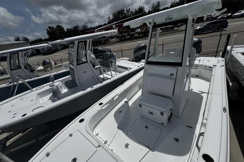 Slide: The Image of 2026 Blazer Bay 2440 boat with center console, parked in a marina under cloudy skies. - 10