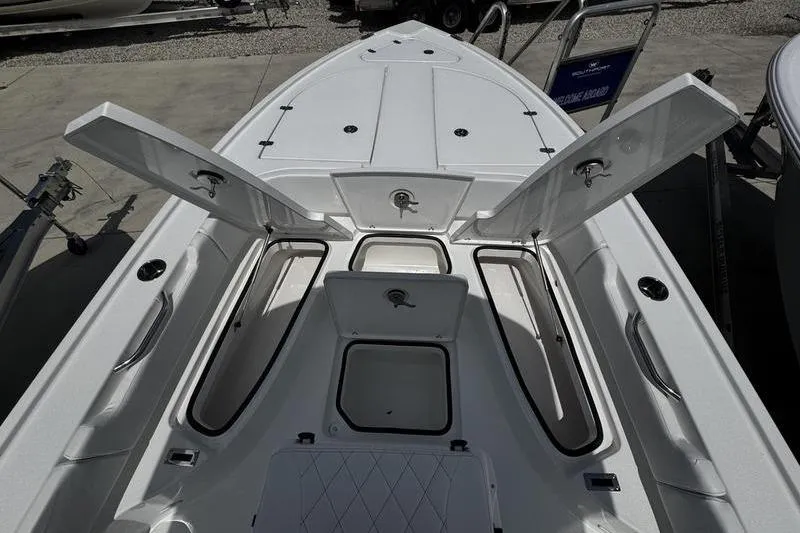 Slide: The Image of 2026 Blazer Bay 2440 boat with open storage compartments on deck. - 12