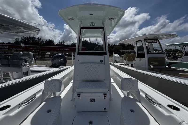 Slide: The Image of 2026 Blazer Bay 2440 boat interior with seating, under a partly cloudy sky. - 14