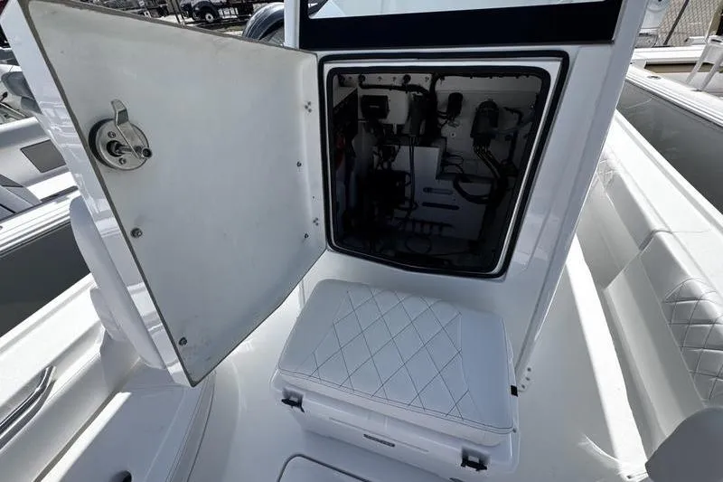 Slide: The Image of 2026 Blazer Bay 2440 boat interior with open storage compartment and cushioned seating. - 17