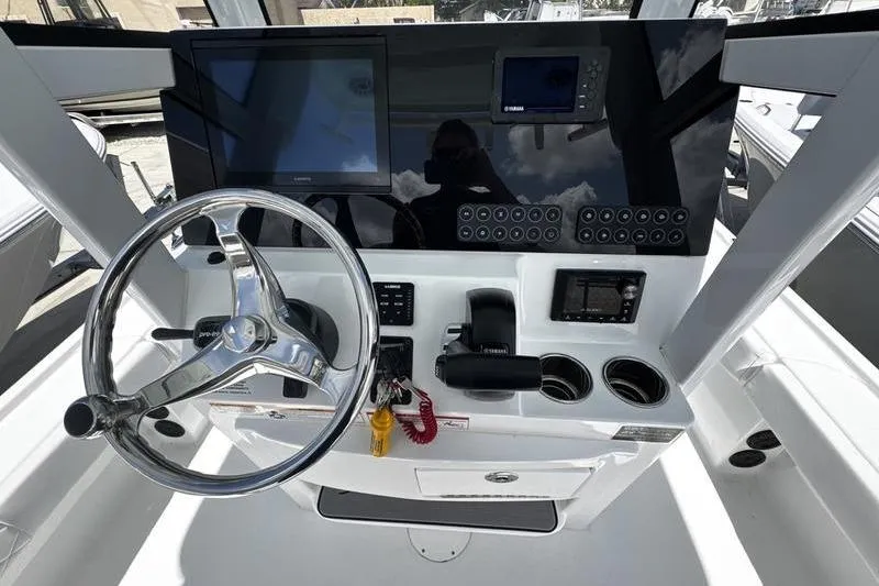 Slide: The Image of 2026 Blazer Bay 2440 boat dashboard with steering wheel and electronic controls. - 22