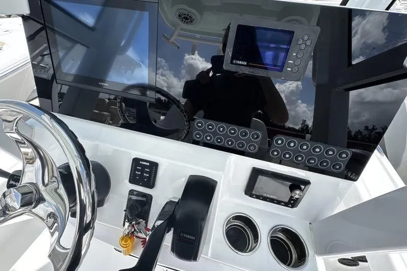 Slide: The Image of 2026 Blazer Bay 2440 boat dashboard with steering wheel and electronic controls. - 23
