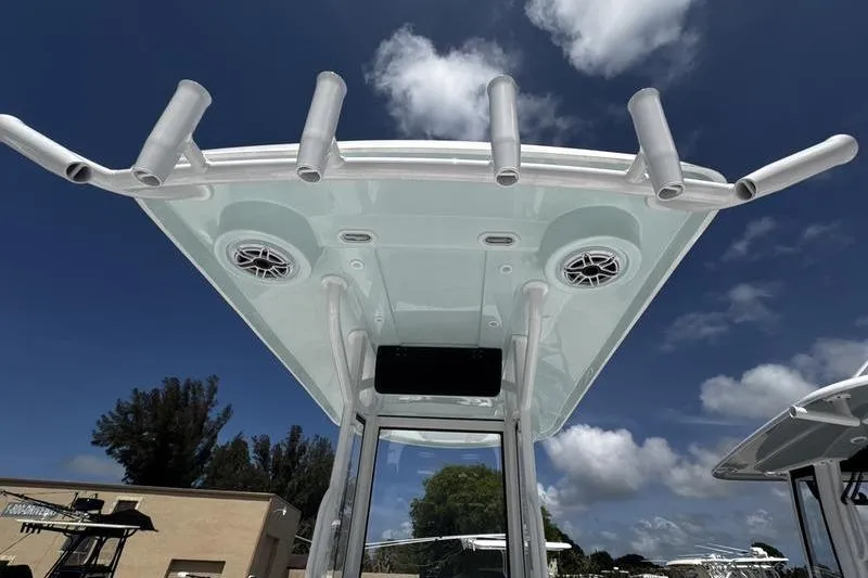 Slide: The Image of T-top view of 2026 Blazer Bay 2440 boat with rod holders and speakers under a blue sky. - 34