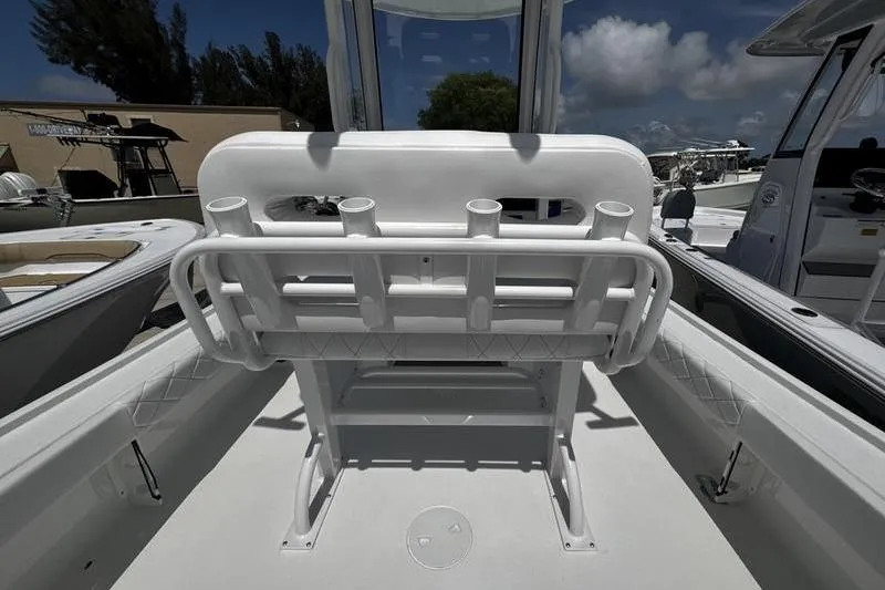 Slide: The Image of 2026 Blazer Bay 2440 boat interior with rod holders and seating, under a clear blue sky. - 35