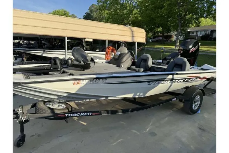 Slide: The Image of 2023 Tracker Pro Team 195 TXW Tournament Edition boat on trailer in driveway. - 2