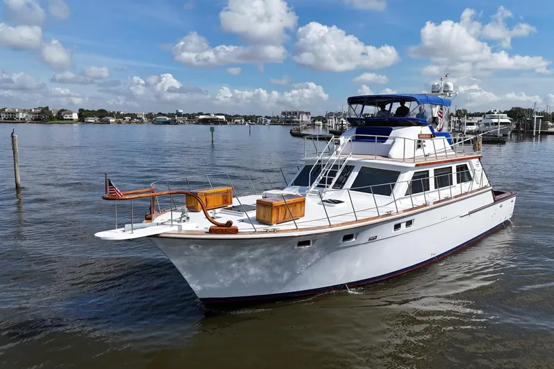 Slide: The Image of 1980 Bertram 58 Convertible yacht on calm water under a partly cloudy sky. - 13