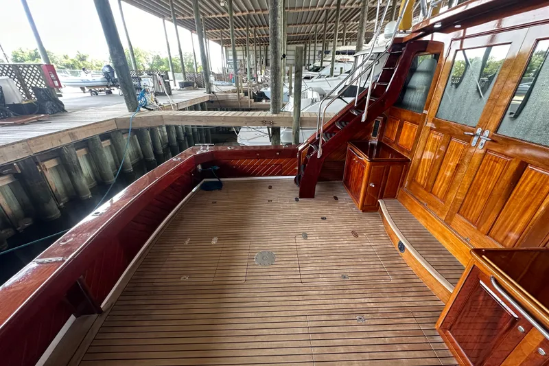 Slide: The Image of 1980 Bertram 58 Convertible yacht deck with wooden finish and dockside view. - 15