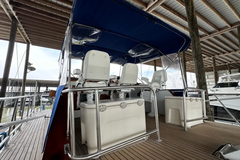 Slide: The Image of 1980 Bertram 58 Convertible yacht interior with blue canopy and white seating. - 17