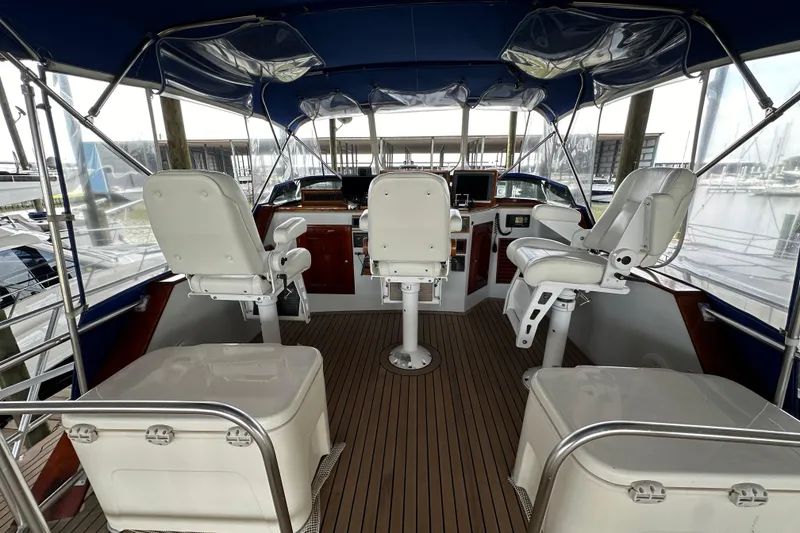 Slide: The Image of Interior view of a 1980 Bertram 58 Convertible yacht cockpit with white captain chairs. - 18