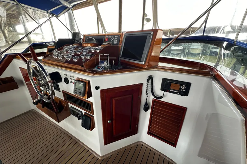 Slide: The Image of Cockpit of a 1980 Bertram 58 Convertible yacht with classic wooden dashboard and steering wheel. - 22