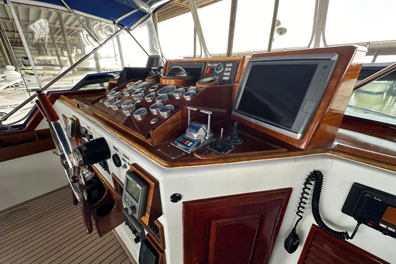 Slide: The Image of Helm of 1980 Bertram 58 Convertible yacht with classic wooden dashboard and modern navigation equipment. - 23